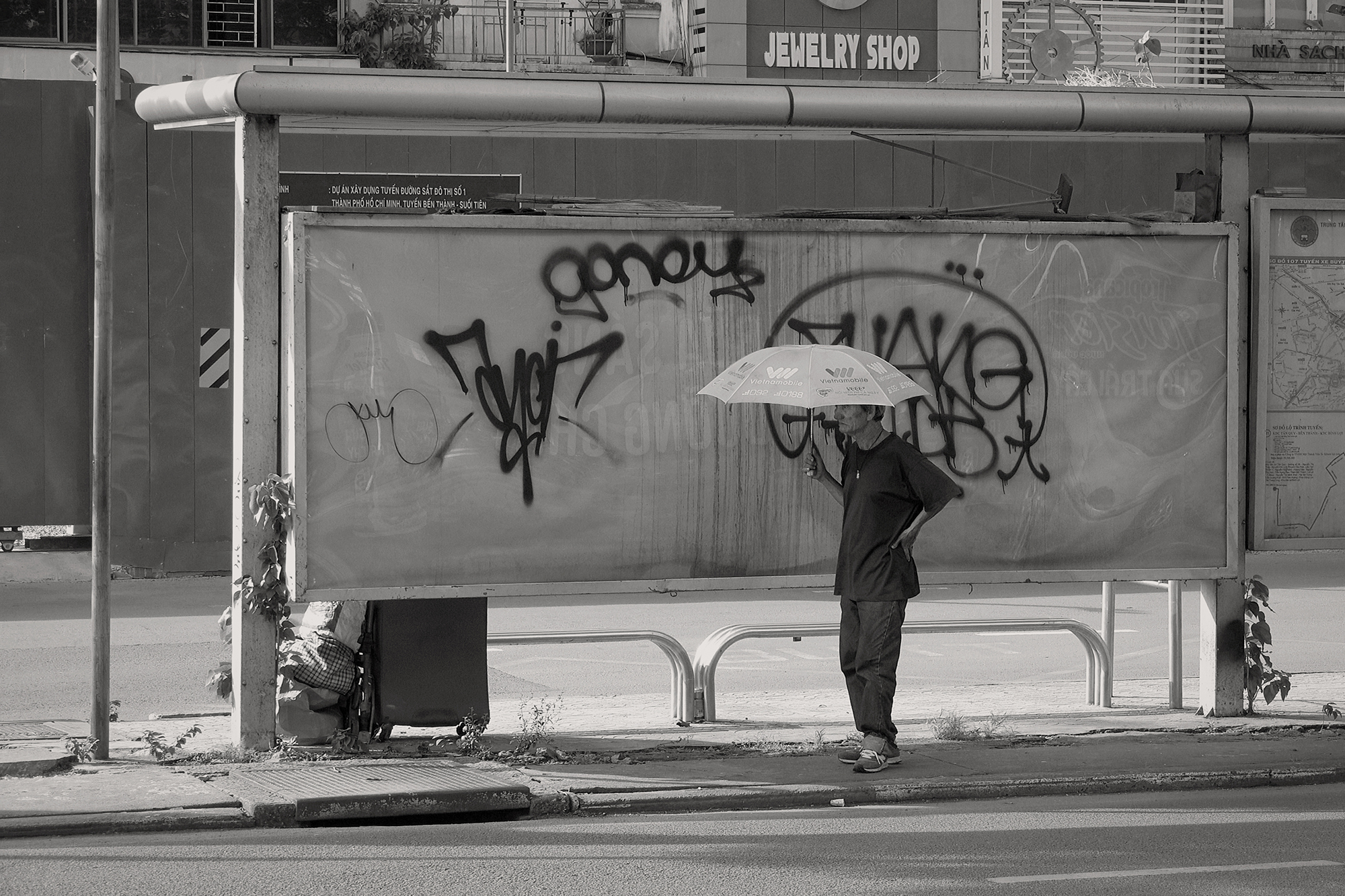 Christoph Radke, Vietnam, Saigon, Alter Mann mit Schirm an einer Bushaltestelle, 2018